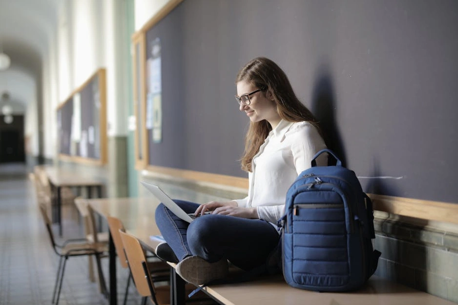 Studente sorridente che lavora al computer in un ambiente moderno